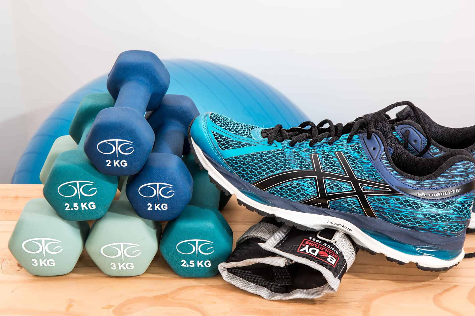 Buty sportowe, hantle i piłka do ćwiczeń po długiej przerwie